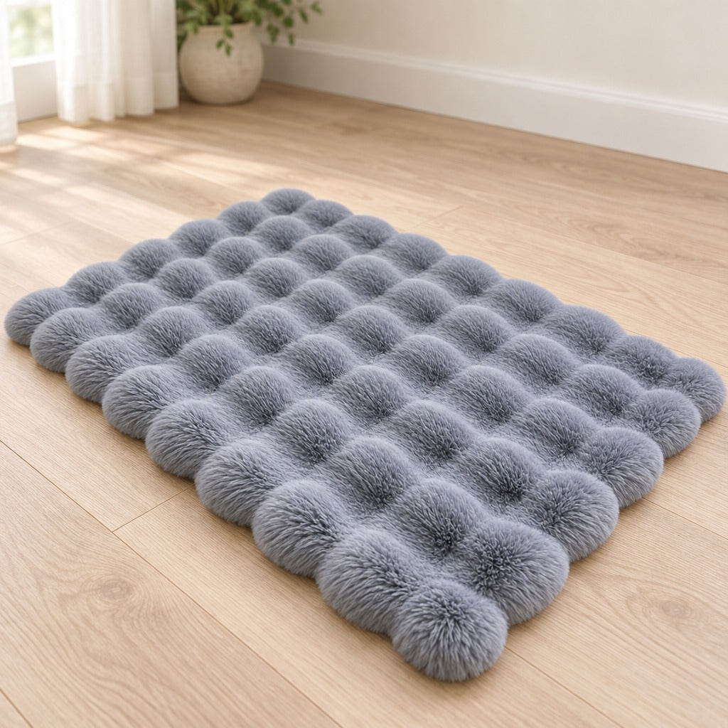 Le tapis bleu ardoise seul, posé à plat sur un parquet clair, son contour festonné bien lisible.
