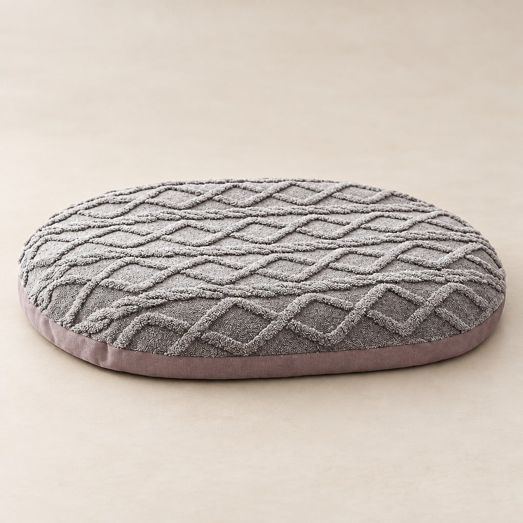 Le tapis gris perle pour chien vu seul de trois quarts sur un fond neutre clair.