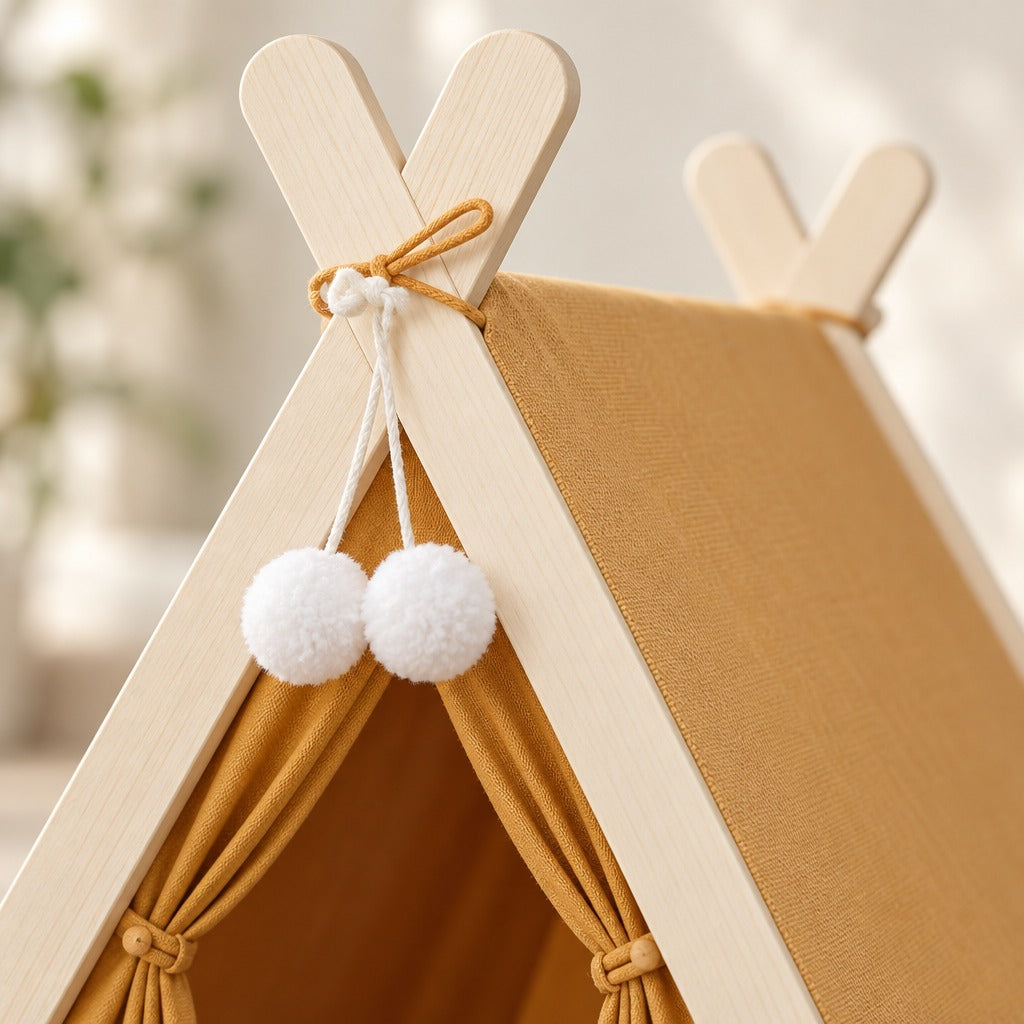 Gros plan sur le croisement des montants de bois blond, le lien et les deux pompons blancs de la tente ocre